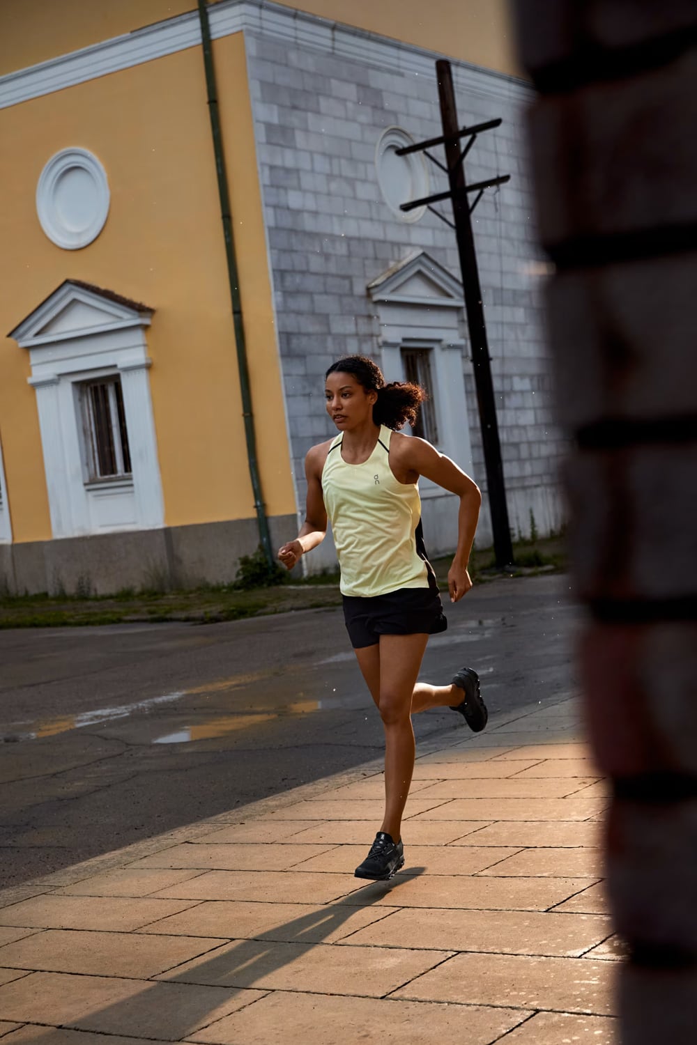 Woman running on a street with a building in the background