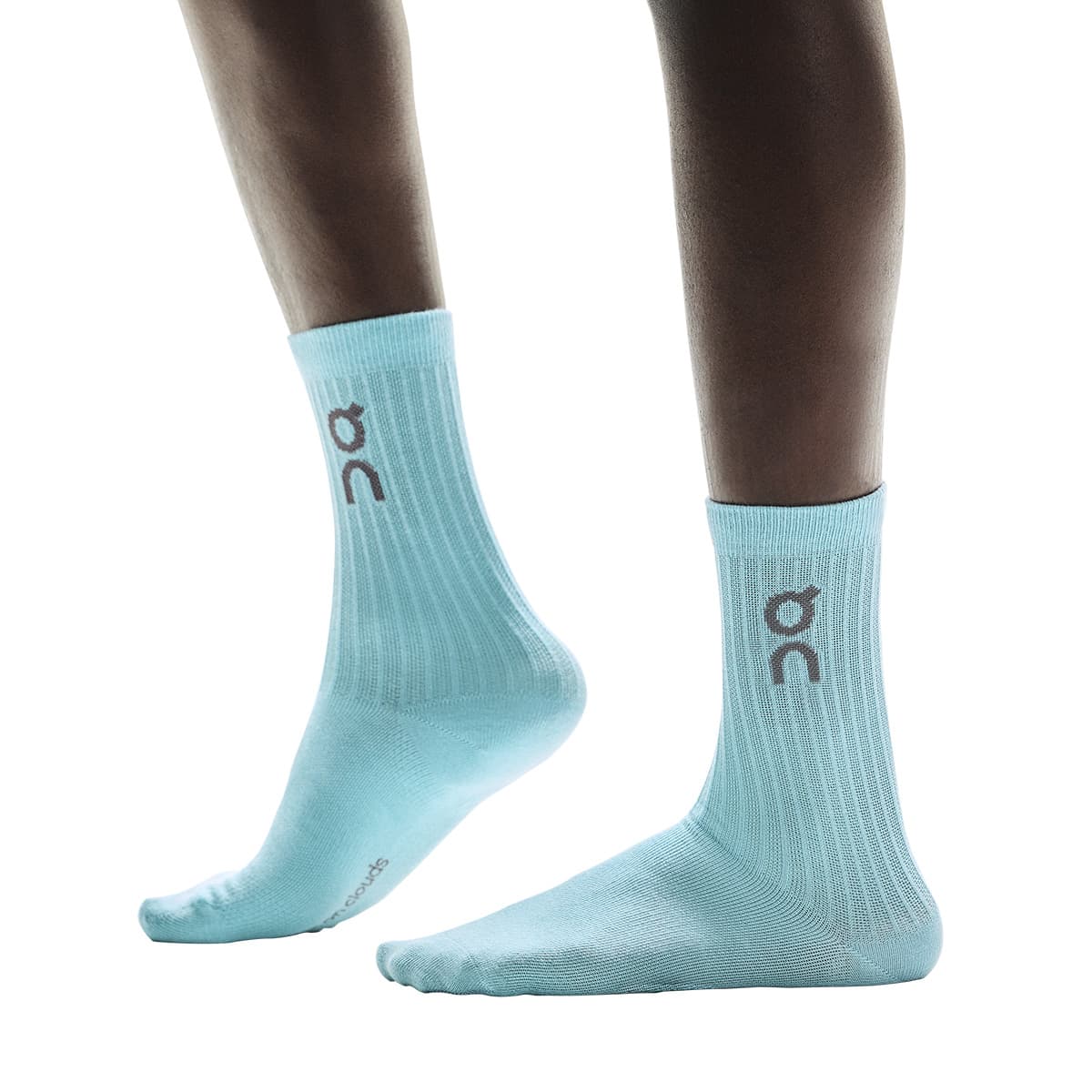 Side view of model wearing the blue pair from the On Logo Sock 3-Pack in Desert Wash