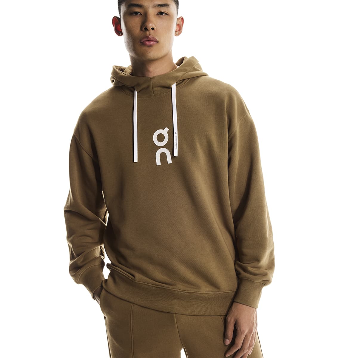 Male model wearing the On Apparel - Club Hoodie Colour Nutmeg in a relaxed pose