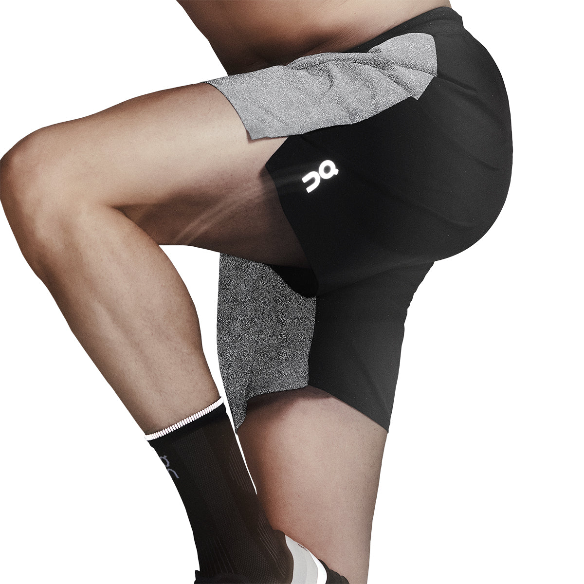 Action pose showing reflective On logo glowing on the On Performance Shorts Lumos in Black