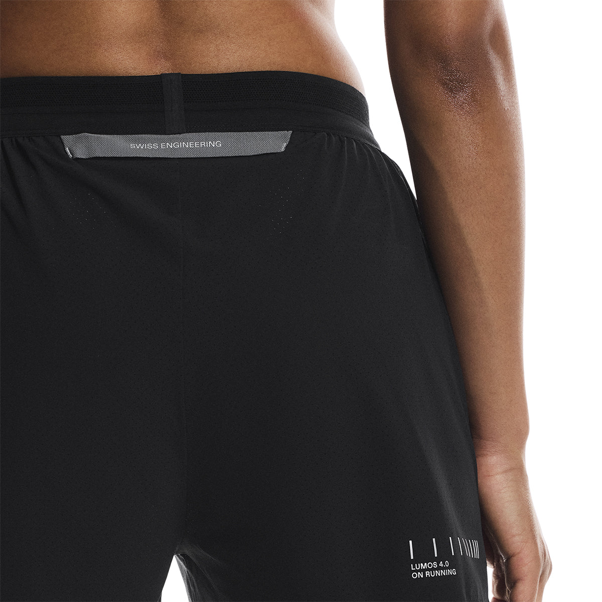 Close-up back view of the On Performance Shorts Lumos in Black showing reflective print and seam