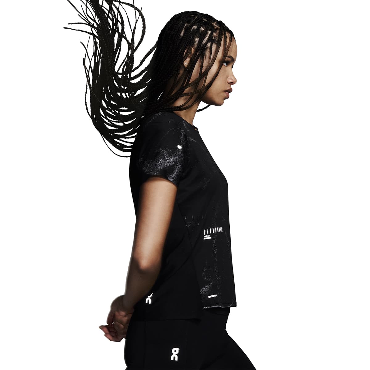 Female model wearing the On Apparel - Performance T Lumos Colour Black in a dynamic pose