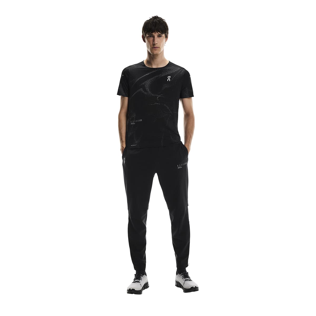 Male model wearing the On Weather Pants Lumos in Black with hands in pockets, front-facing