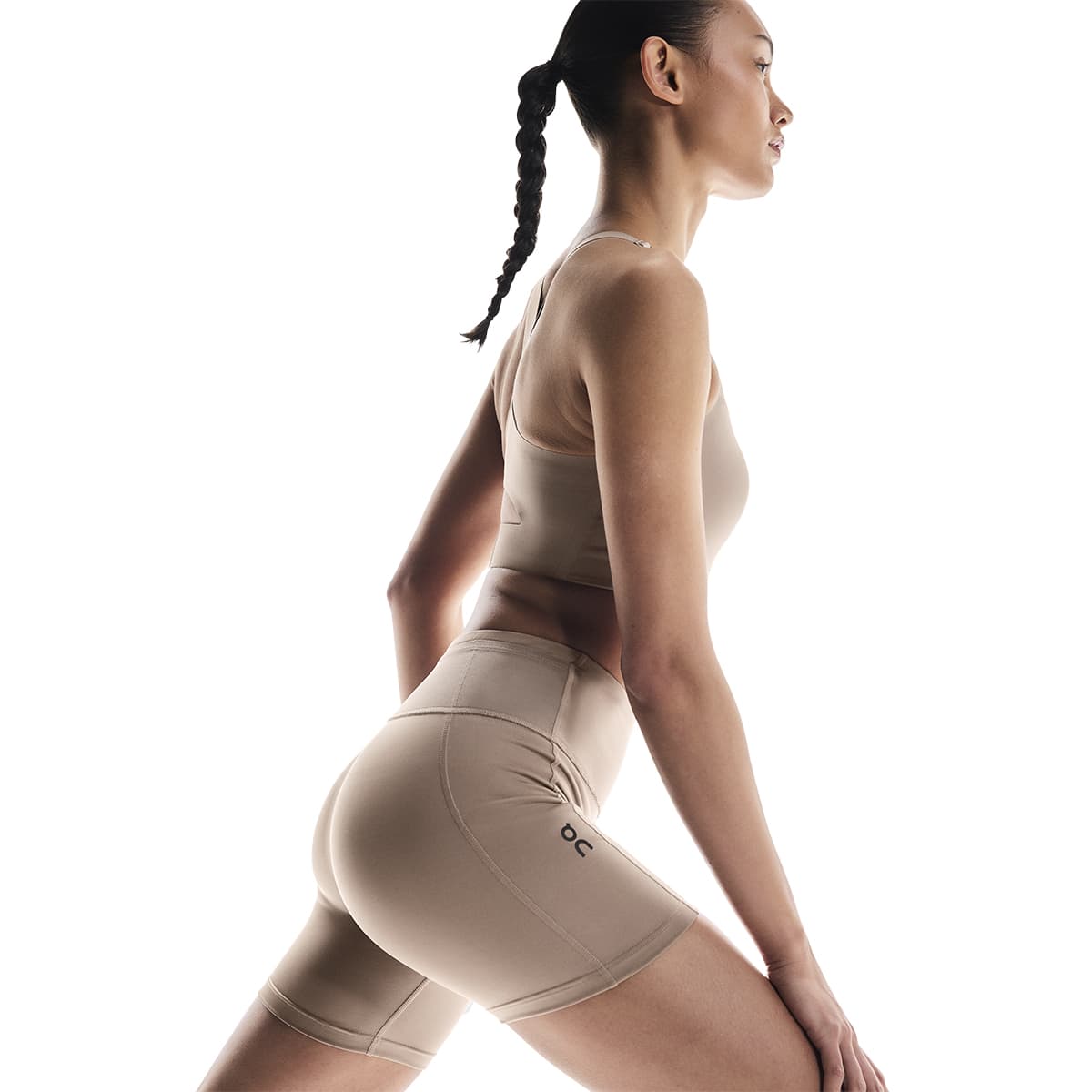 Woman wearing the On Performance Short Tights Colour Cinder - Stretching Side Shot