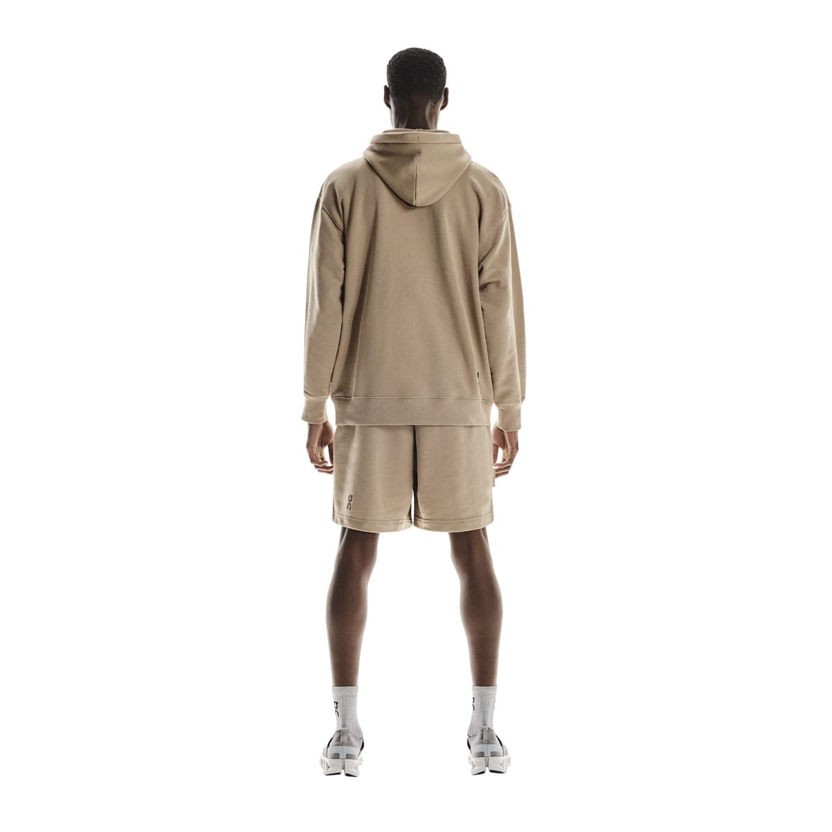 Full back view of male model wearing the On Club Hoodie in Desert