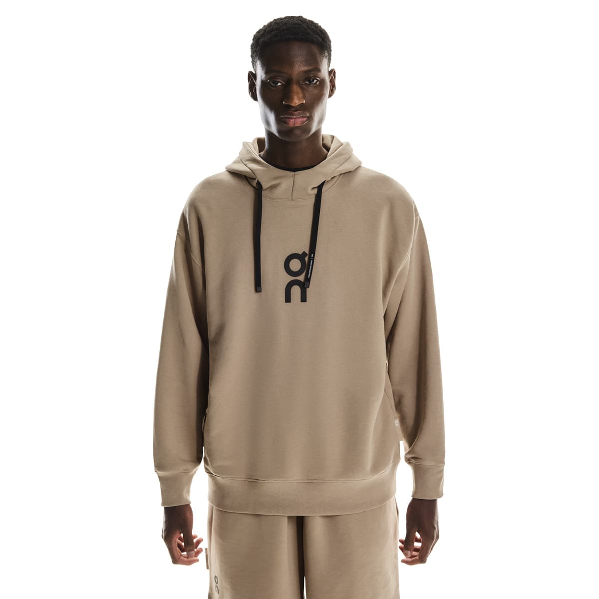Cropped front view of male model wearing the On Club Hoodie in Desert