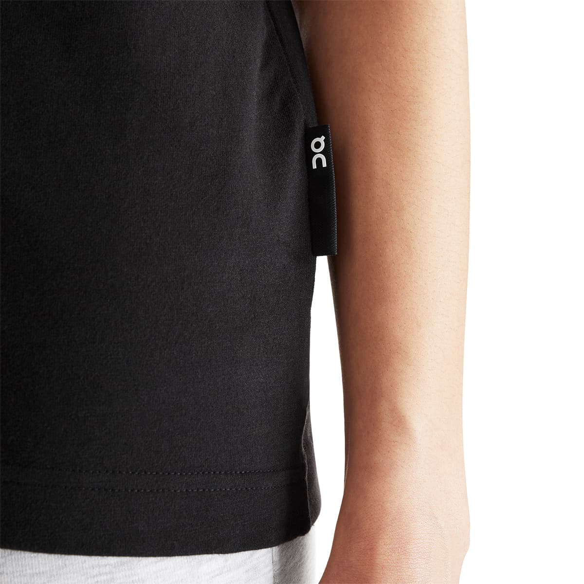 Women wearing the On Club T Colour Black - Close up Logo tag