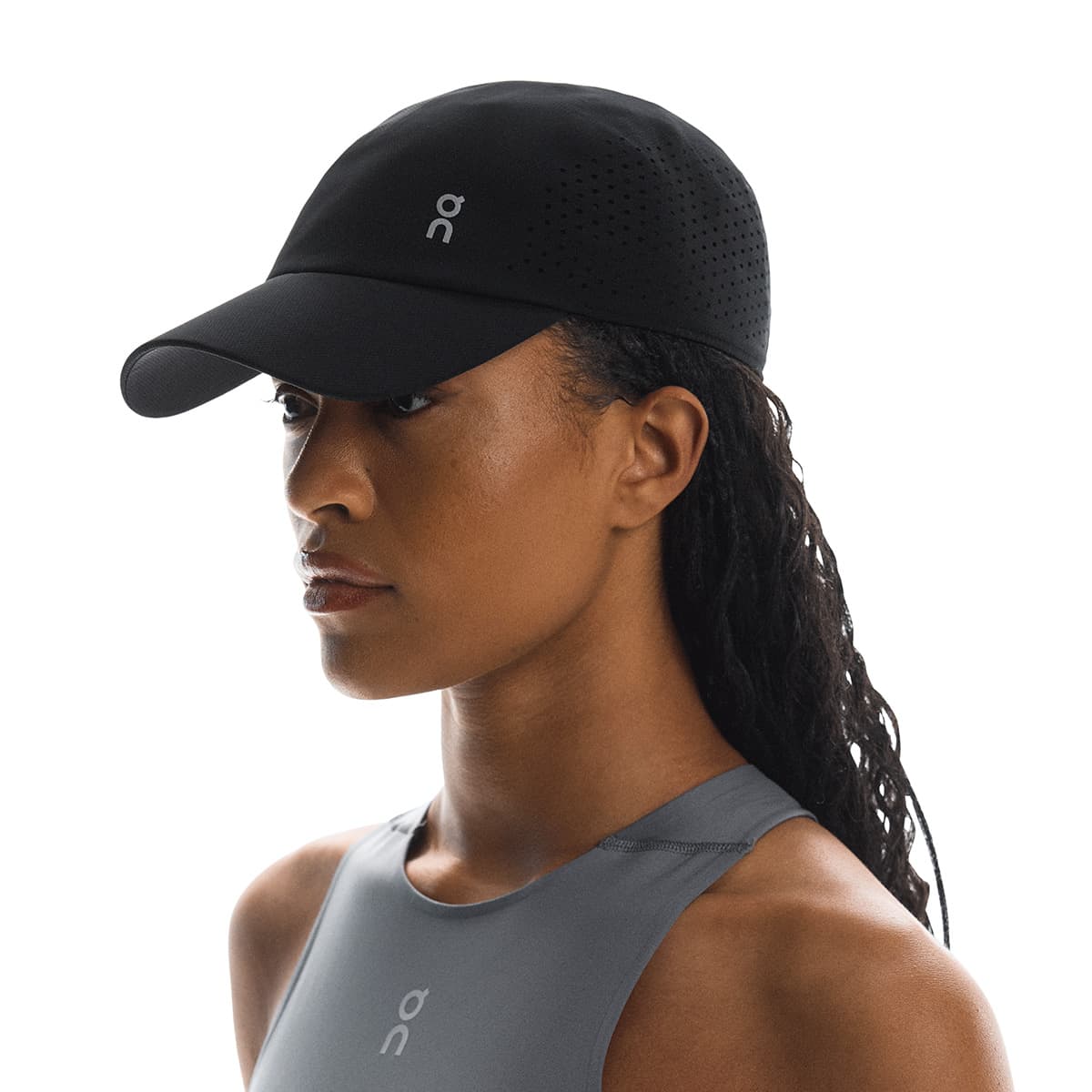 Front angled view of female model wearing the On Lightweight Cap in Black