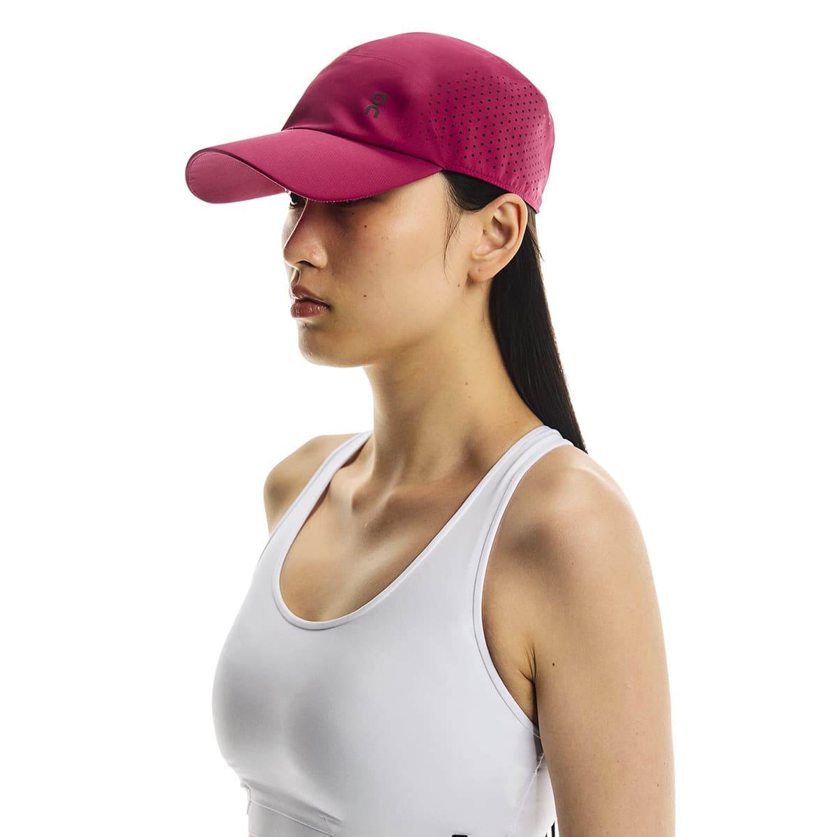 Front angled view of female model wearing the On Lightweight Cap in Grenadine