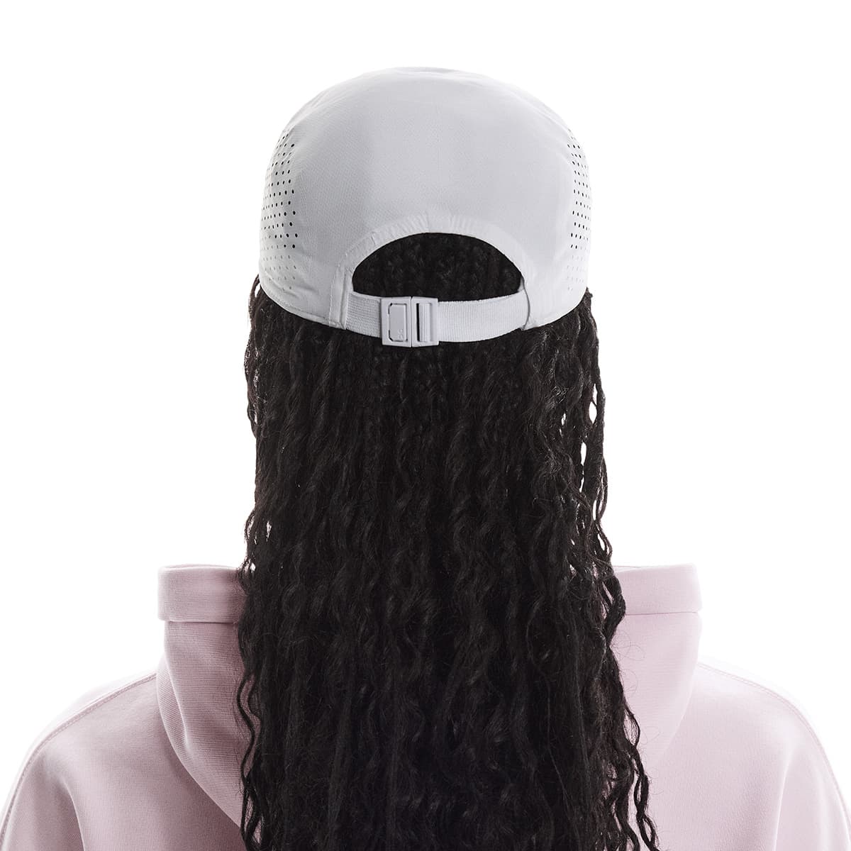 Rear view of female model wearing the On Lightweight Cap in White showing adjustable strap