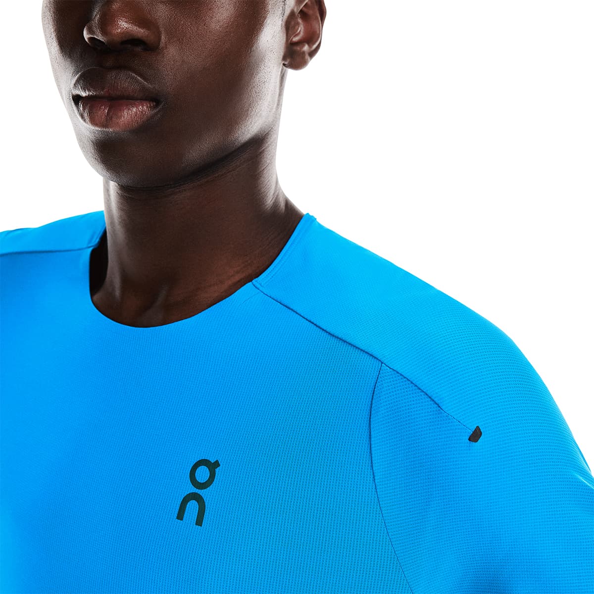 Man wearing the On Performance T Colour Malibu-Navy - Front Detail Logo