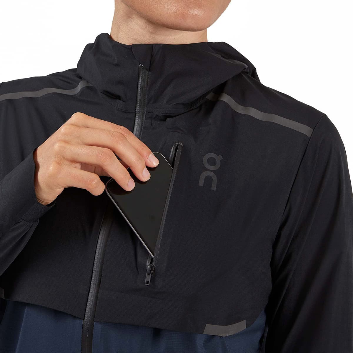 Woman wearing the On Weather Jacket Colour Black Navy - Front Secure Pocket