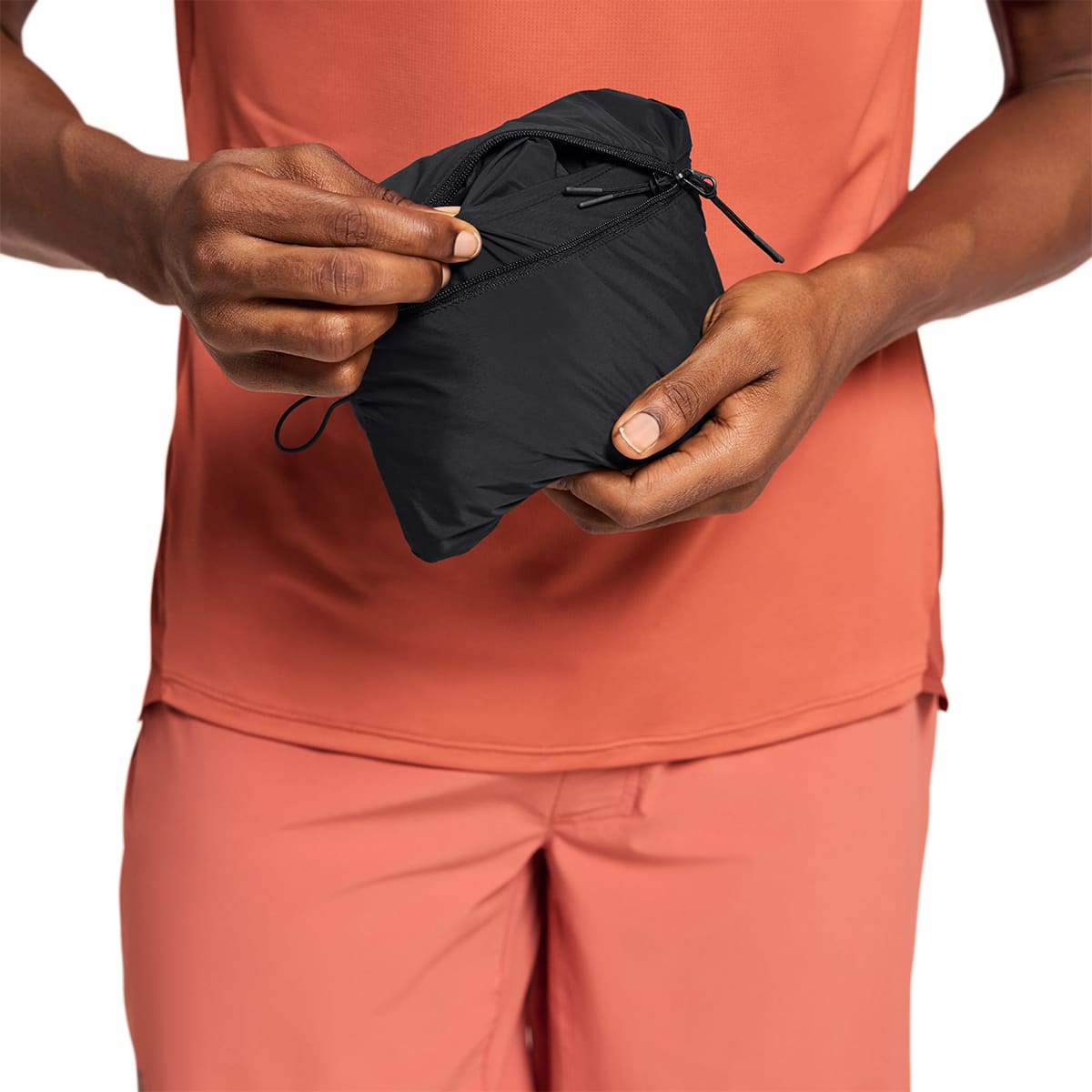 Man wearing the On Weather Jacket Colour Black - Jacket Folding into itself