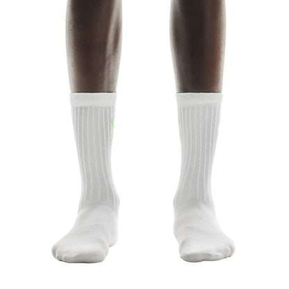 Front view of model wearing the white pair from the On Logo Sock 3-Pack in Desert Wash 