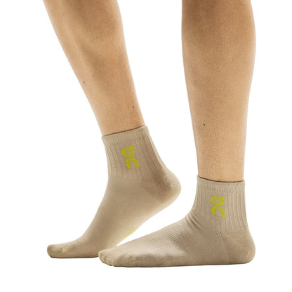 Side view of model wearing the beige pair from the On Logo Sock Mid 3-Pack in Desert Wash 