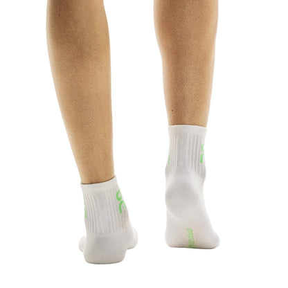 Rear view of model wearing the white pair from the On Logo Sock Mid 3-Pack in Desert Wash 