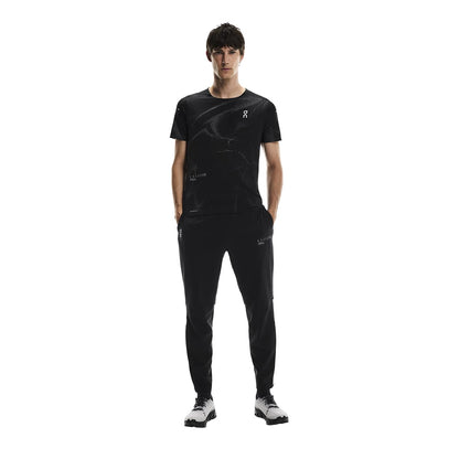 Male model wearing the On Weather Pants Lumos in Black with hands in pockets, front-facing 