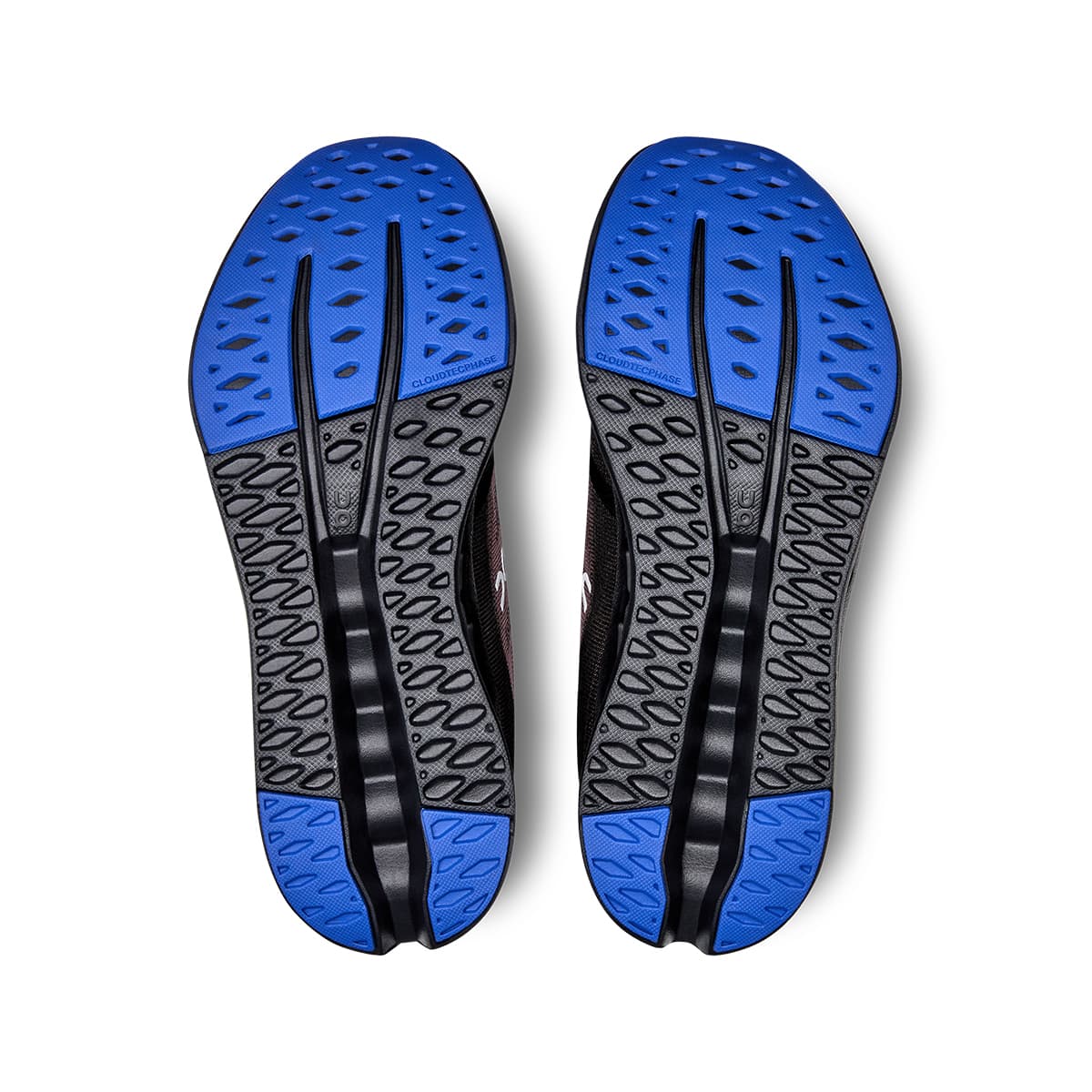 Soles of the On Cloudsurfer Black-Cobalt women’s running shoes 