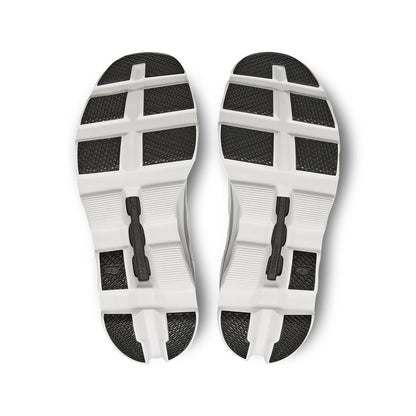 Soles of the On Cloudmonster All White women’s running shoes 