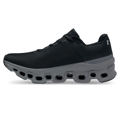 Left side view of the On Cloudmonster Black Magnet women's running shoe 
