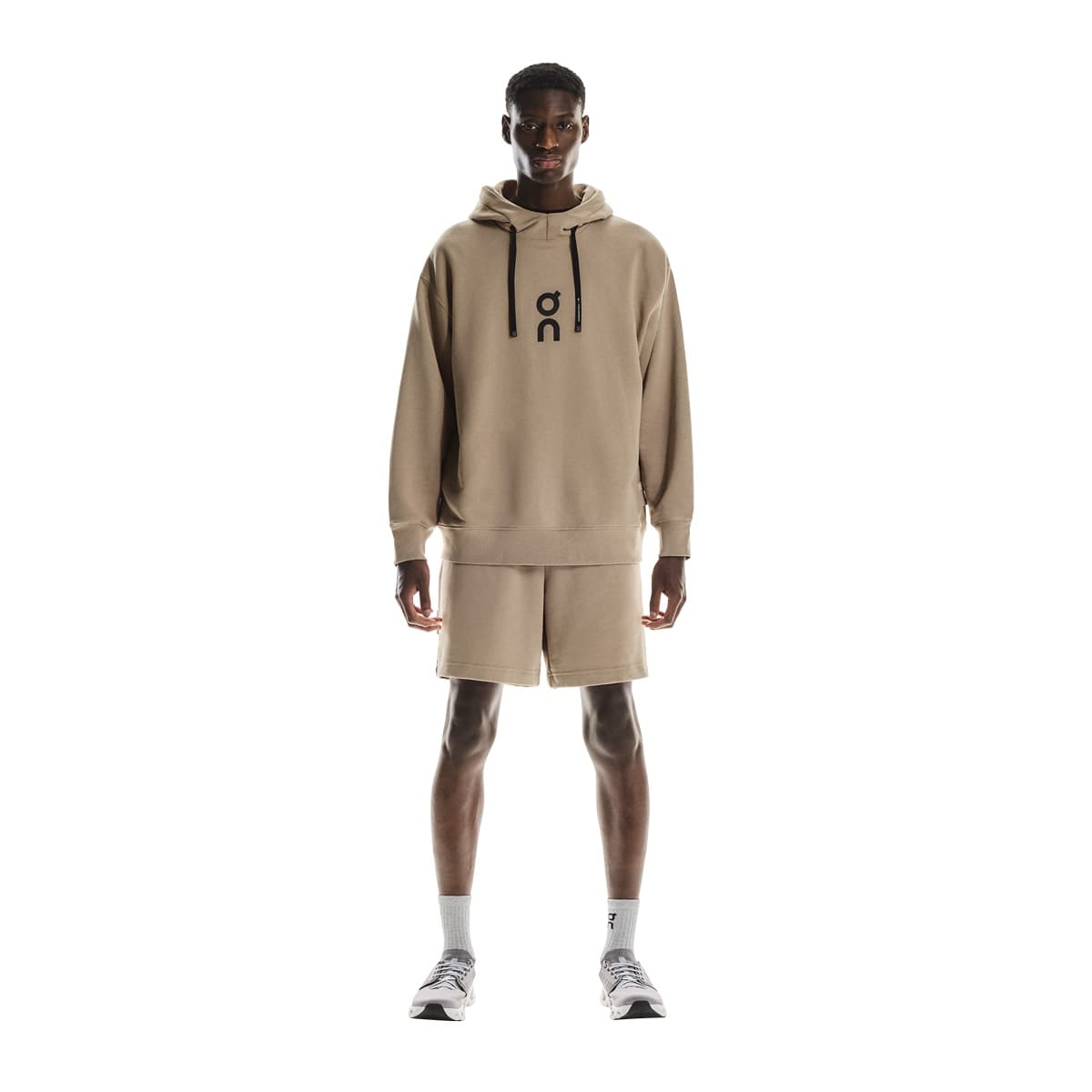 Full front view of male model wearing the On Club Hoodie in Desert 