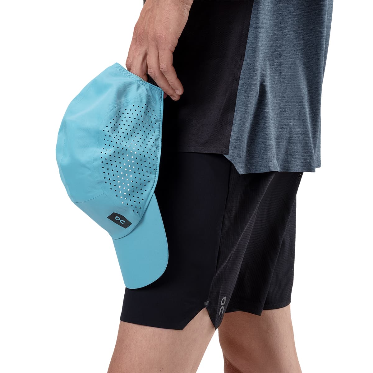 Male Model holding the On Lightweight Cap Colour Niagara 