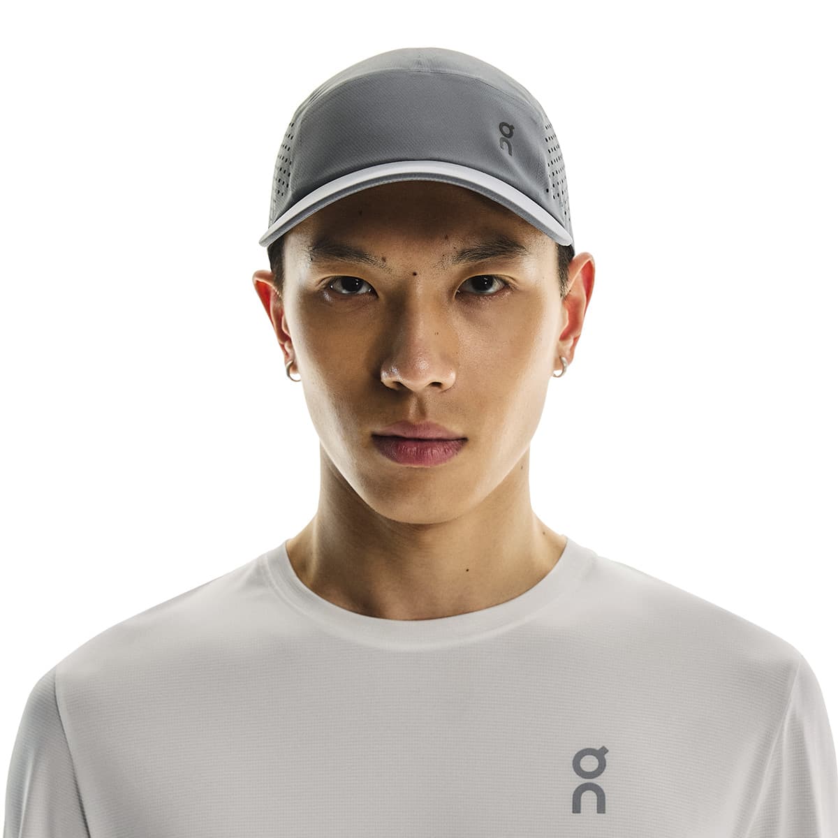 Front view of male model wearing the On Lightweight Cap in Rock #color_rock