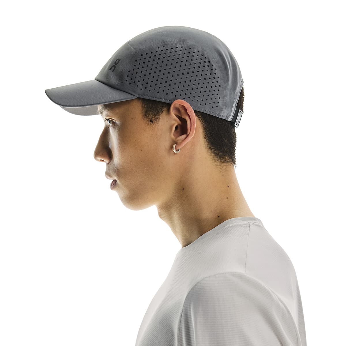 Side profile of male model wearing the On Lightweight Cap in Rock #color_rock