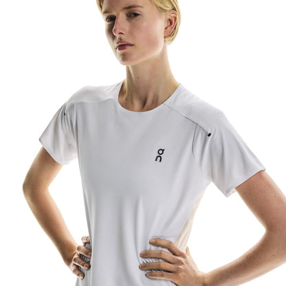 Angled front view of female model in the On Performance T in White Silver with hands on hips 