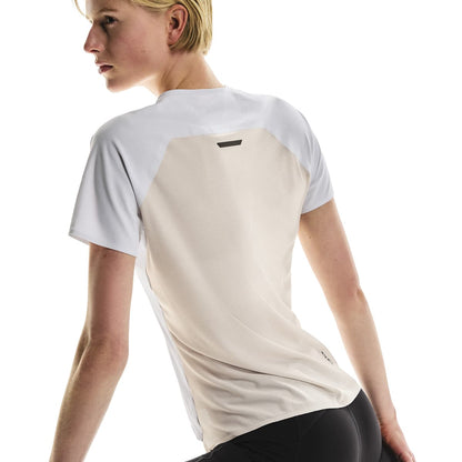 Angled back view of female model in the On Performance T in White Silver showing contrast panel 
